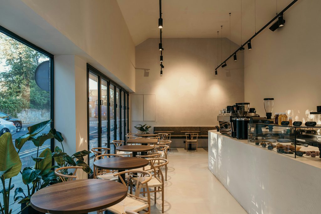 Inside Little Café — clean chairs and tables in a warm, inviting atmosphere.